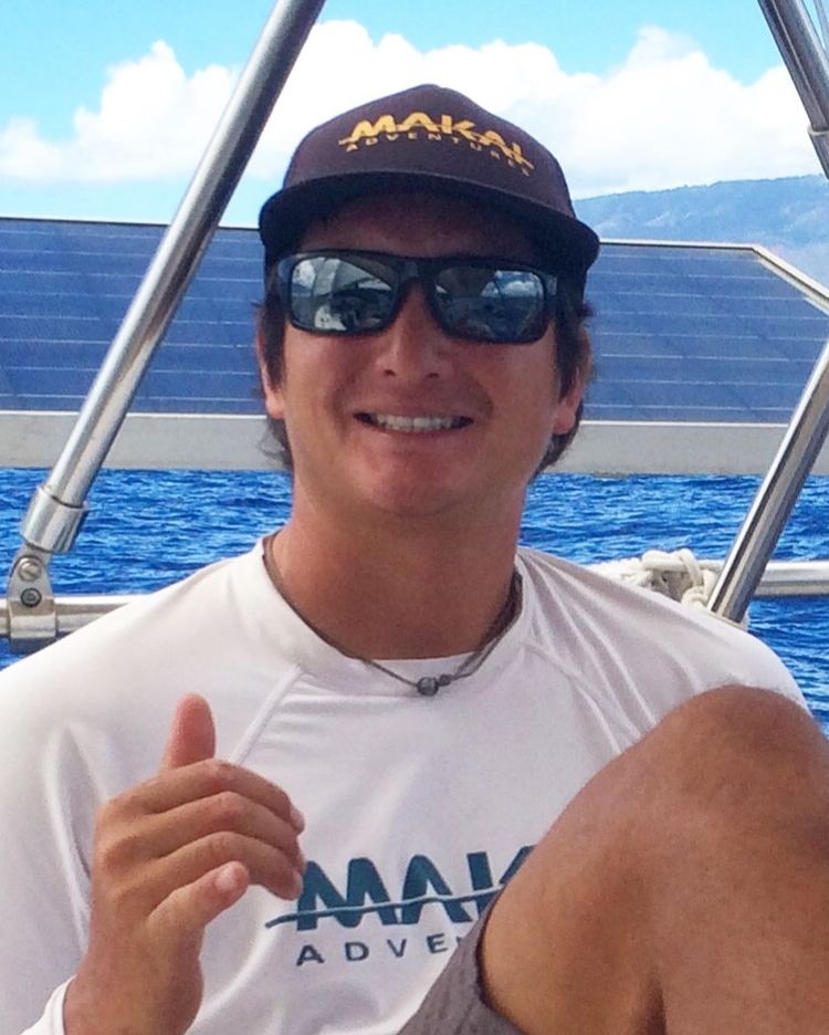 Captain Keao, owner of Kainani Sails, smiling aboard with the solar panels behind him
